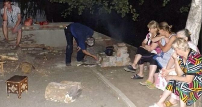 Люди оборудовали костер, на нем готовят еду. На дверь подъезда поставили засов. — О визите в Луганск