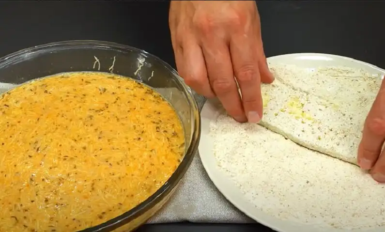 В другую миску разбиваем яйца, добавляем травы, соль, молотый перец, паприку, взбиваем. Добавляем сыр, натирая его на мелкой терке. 